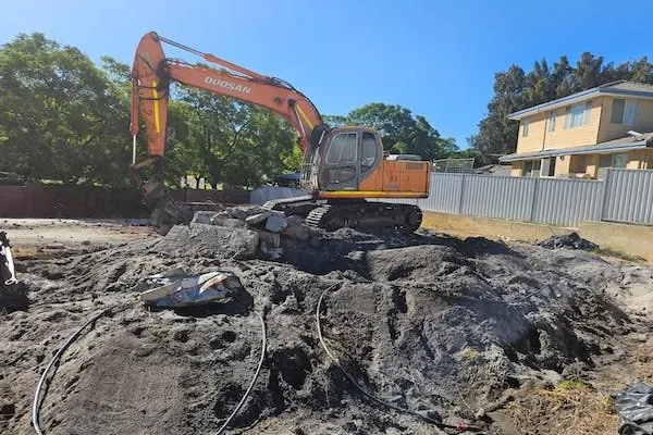 Excavator levelling a cleared residential block