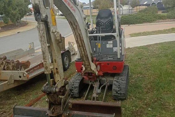 Compact excavator loaded on a trailer